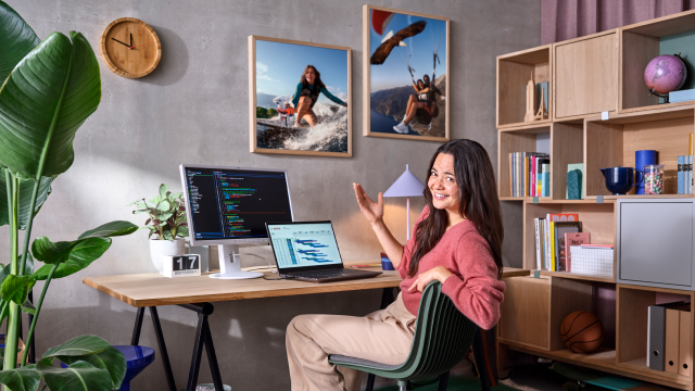 Two associates are standing in front of a football table together with a Bosch Rexroth APAS assistance robot.