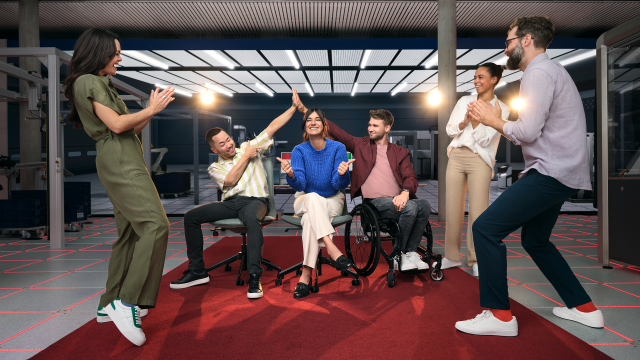 Two associates are playing on a football table with a Bosch Rexroth APAS assistance robot.