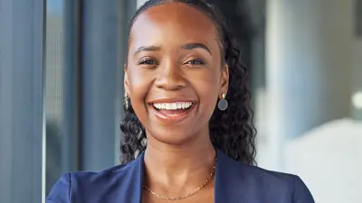 Portrait of a person wearing a blue blazer with arms crossed.