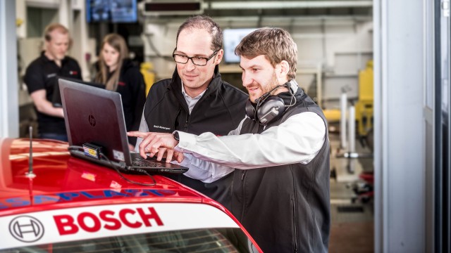 Two Bosch associates analysing the measured values of a racing car.