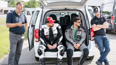 ABS motorcycle test riders and Bosch engineers in a car