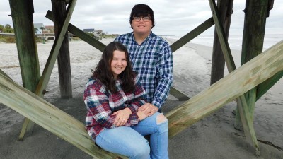 Stephanie Walters and her Fiancee are sitting on the beach.